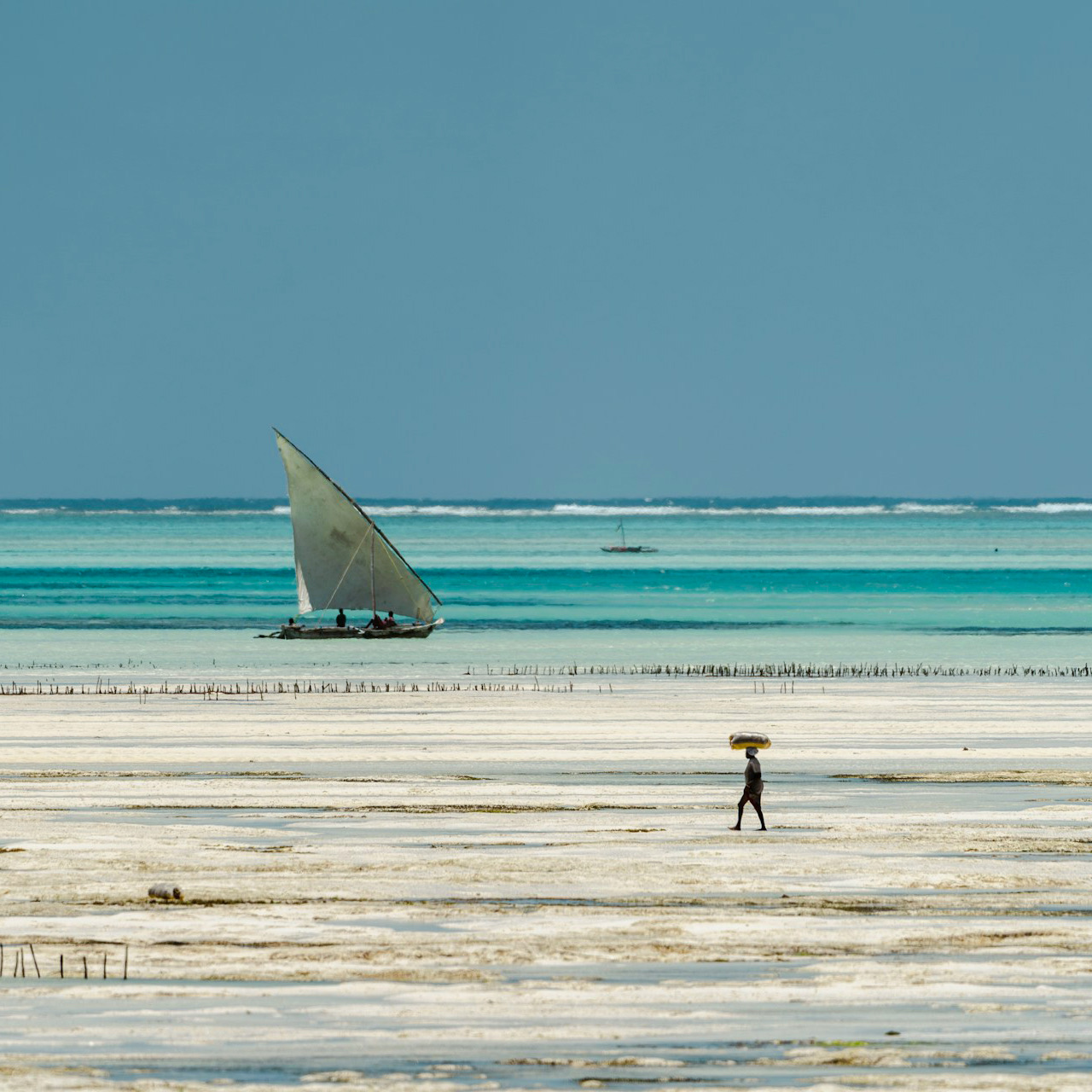 A dhow under sail off the Zanzibar coast at low tide